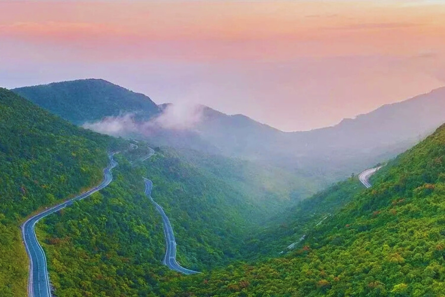 Hai Van Pass winding mountain road at sunset on a scenic Vietnam road trip